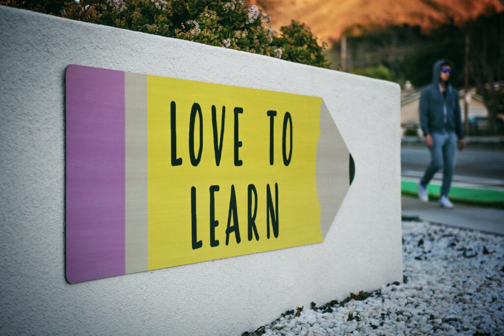 love to learn sign with person walking in background | Innovators Central