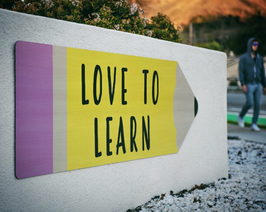 love to learn sign with person walking in background | Innovators Central