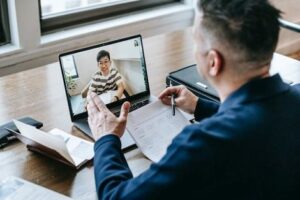 man holding paperwork while on a video conference | Innovators Central