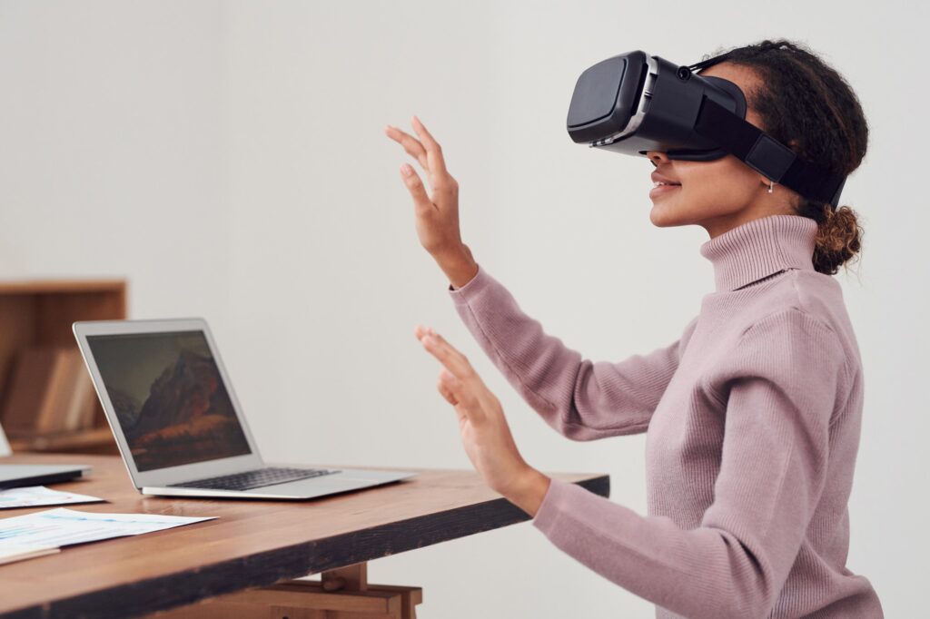woman wearing VR goggles at desk in the workplace