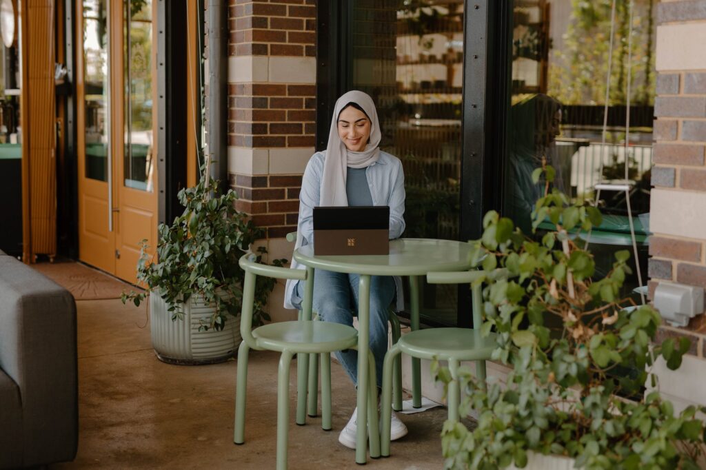 woman sitting at table outdoors with laptop | Innovators Central