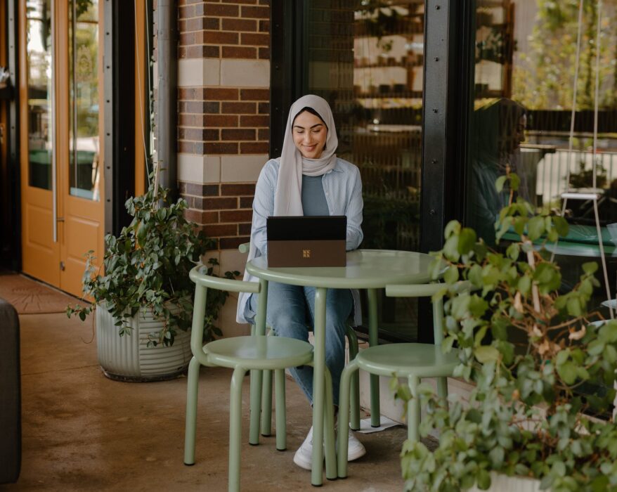 woman sitting at table outdoors with laptop | Innovators Central